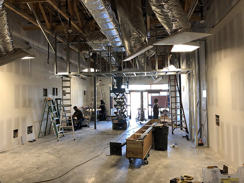 Photo showing new partition walls and duct work of overhead HVAC system. 